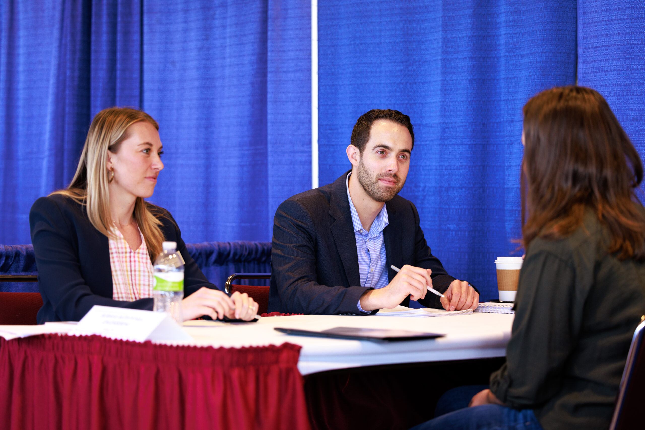Two representatives of a company conducting an interview with a student during Mass Interview Day,