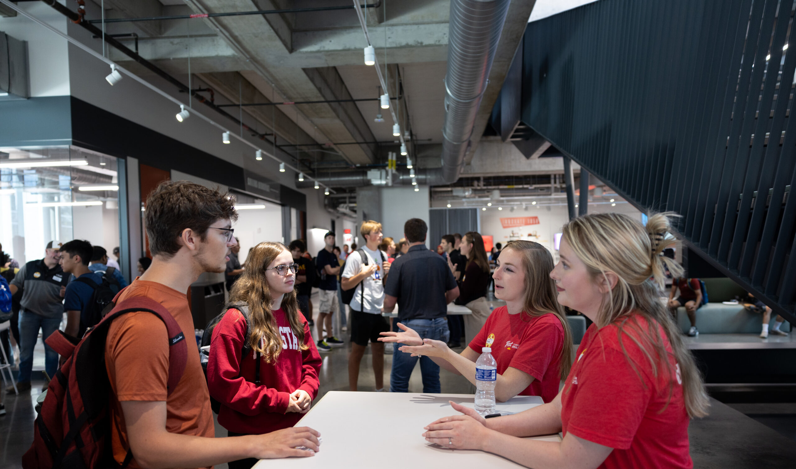 Photo of two employers having a casual networking conversation with two students.