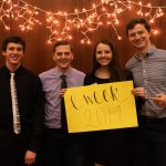 students holding eweek sign