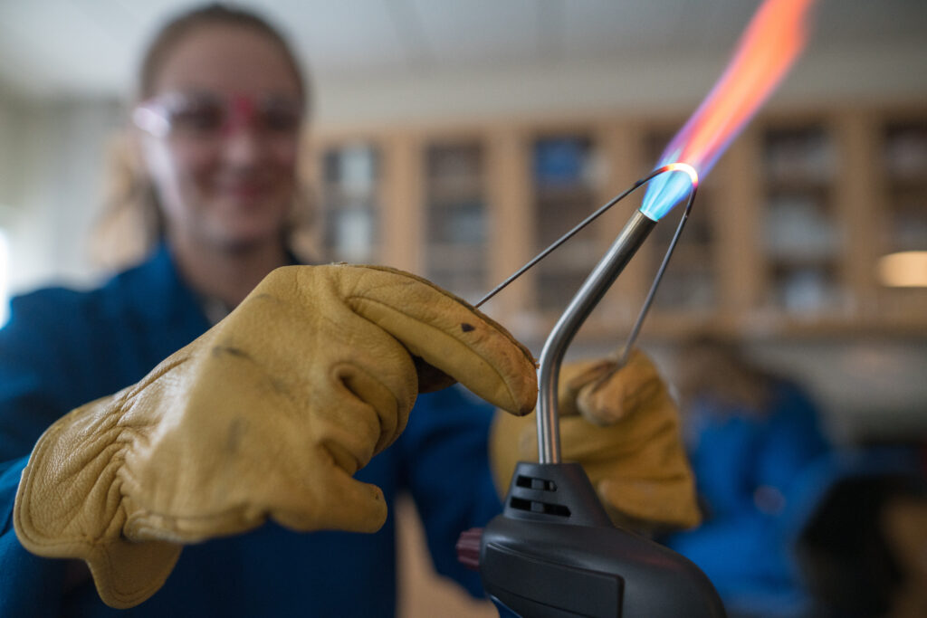 student heating testing wire in laboratory