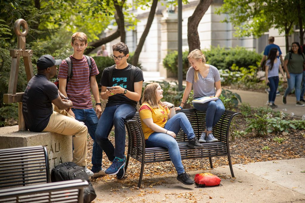 students gathered at outside bench