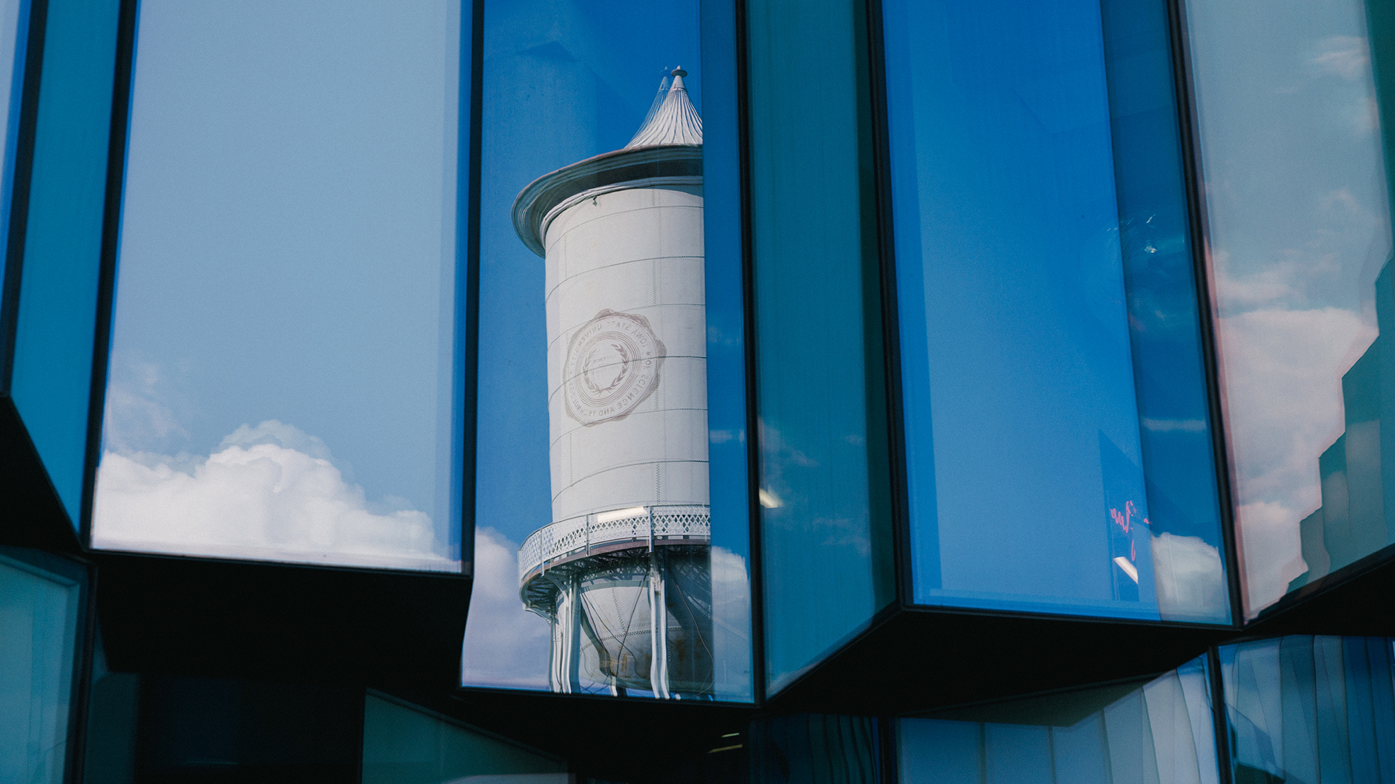 Water tower reflected in windows of Student Innovation Center on the Iowa State campus.