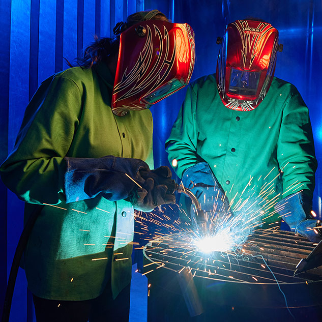 students welding in lab setting