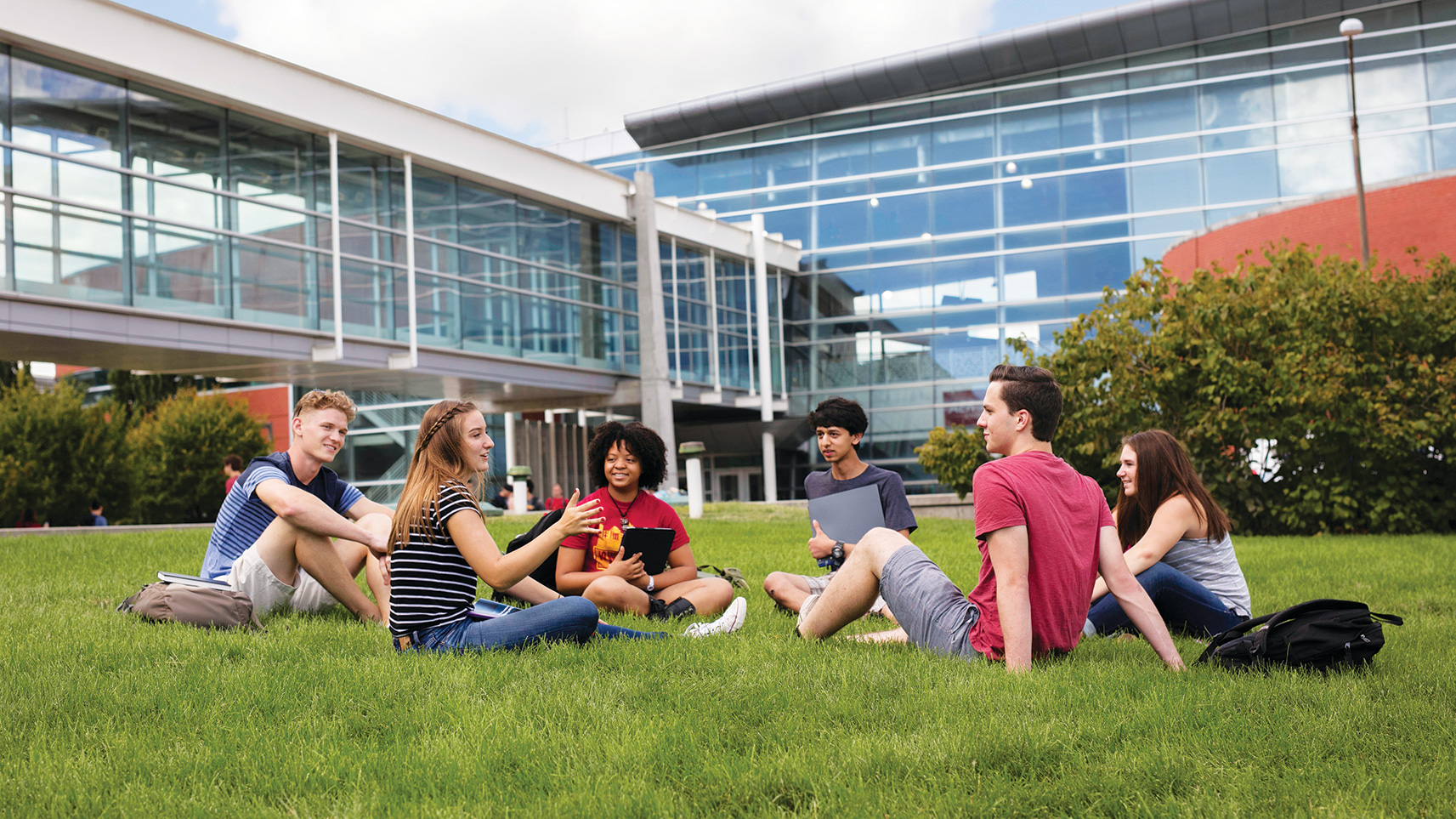 students interacting in a grassy outdoor area