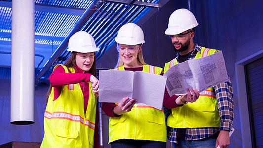 professor and students review plans at a construction site