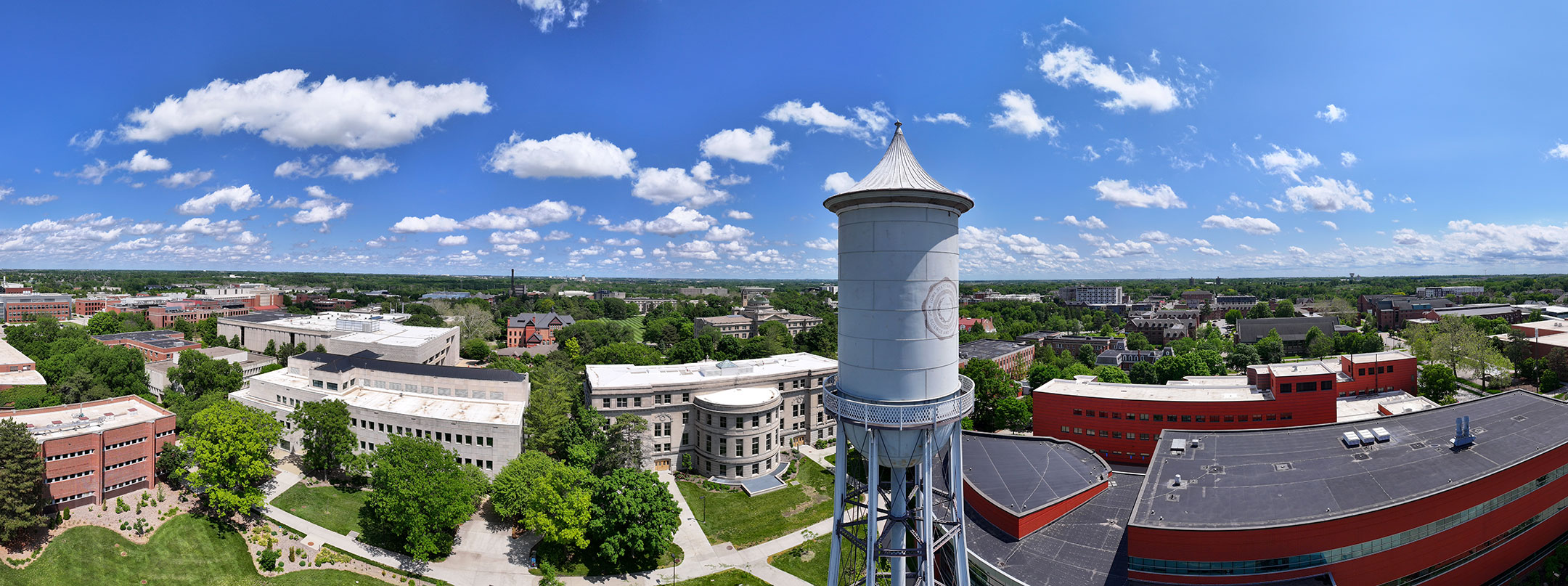 drone view of the Marston Water Tower and campus with blue sky and clouds overhead