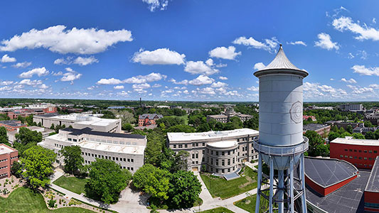 drone view of Marston Water Tower and campus with blue sky and clouds overhead