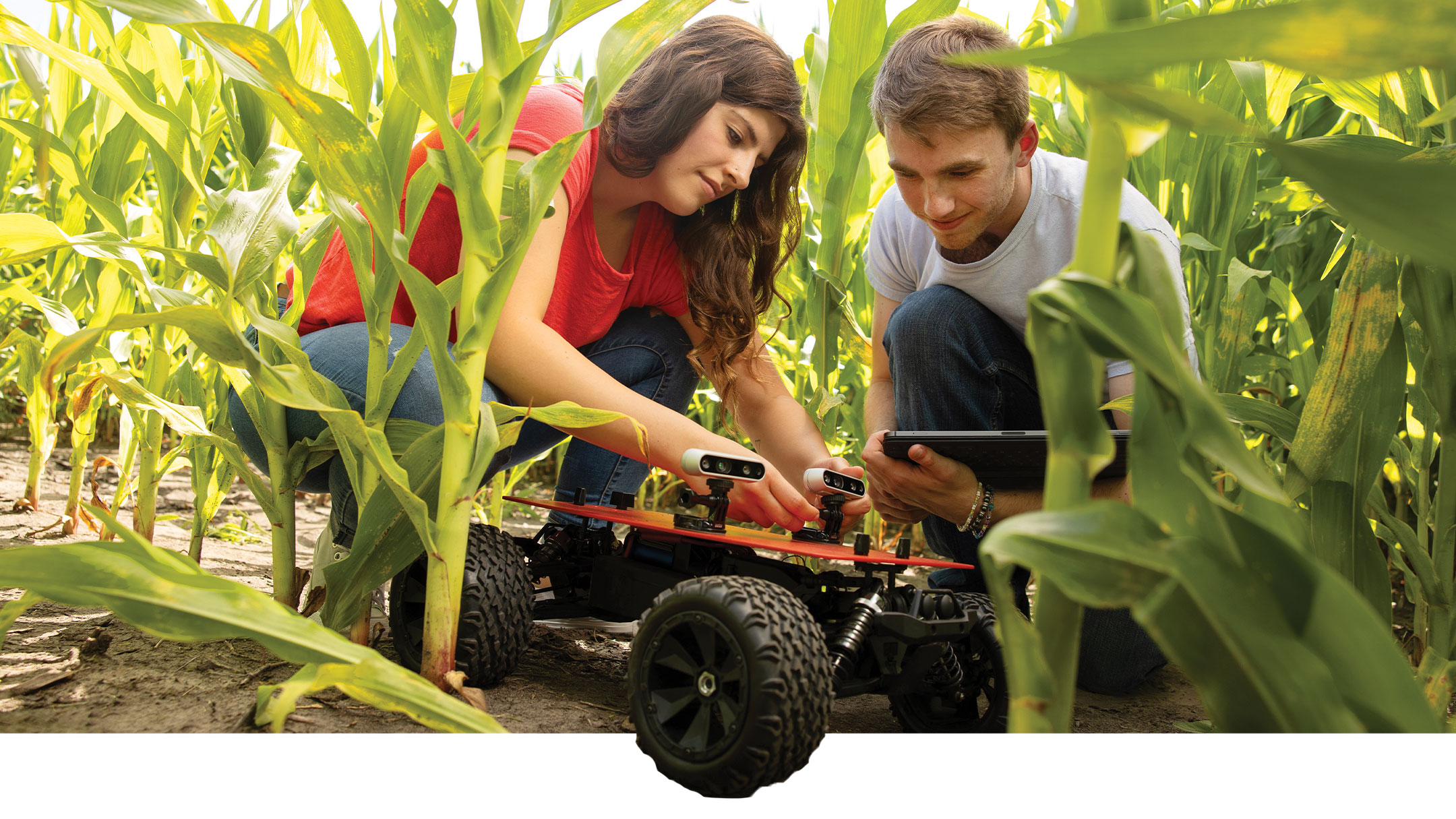 Students in the field work on remote vehicle technology that monitors crop and soil conditions