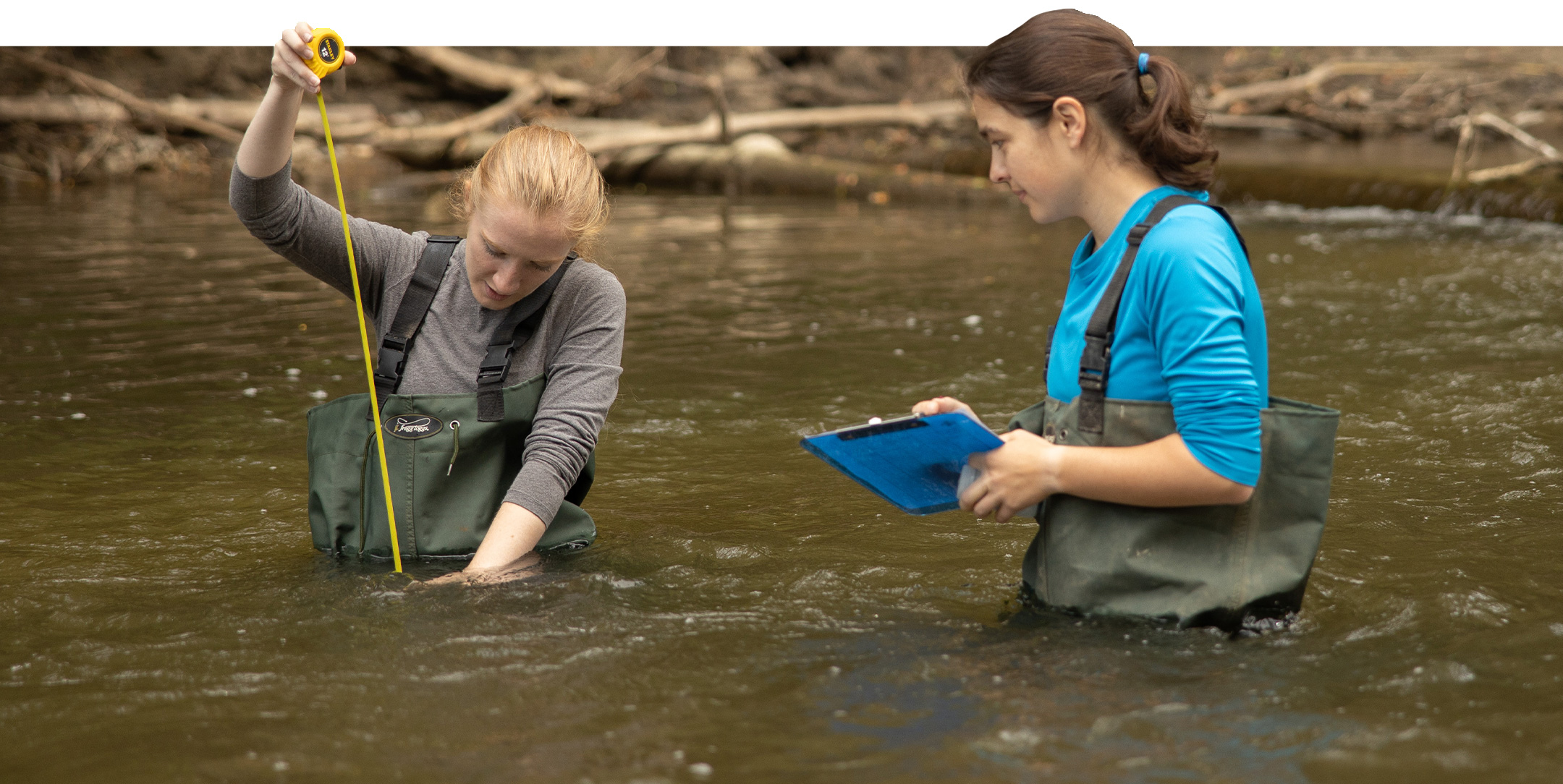 Students measure the water level of a creek