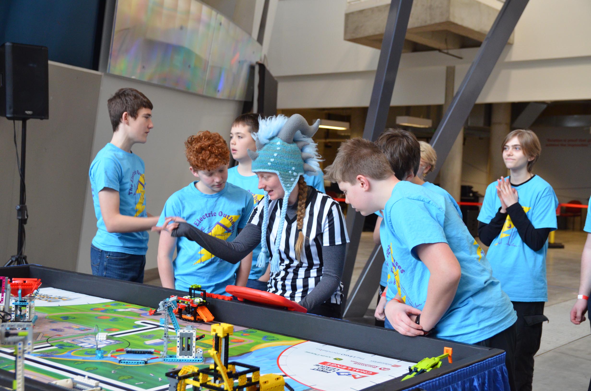 FIRST LEGO League referee explaining the rules to a group of boys.