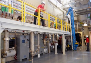 Marty Haverly, top left, and Lysle Whitmer, bottom right, inspect recent upgrades to Iowa State University's pilot-scale fast pyrolysis equipment. - Photo by Bob Mills of the Bioeconomy Institute