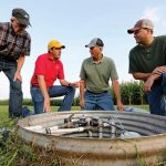 Matt Helmers with farmers in field