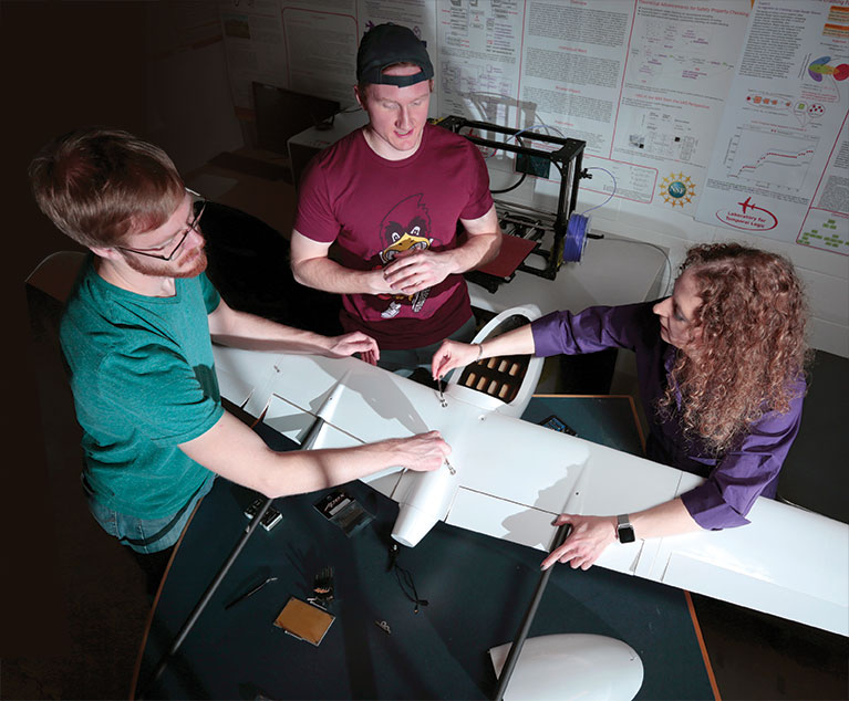 Professor Kristin Rozier works with students on drone