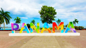 Panama signage with palm trees and shoreline in the background